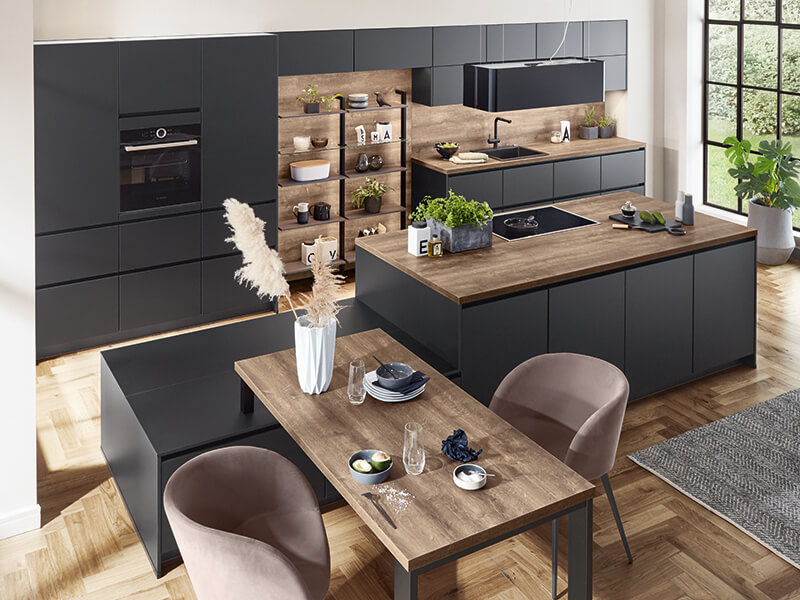 moderne große Kücheninsel und Küchenzeile in dunkel grau schwarz und Holz-Optik mit Elektrogeräte﻿